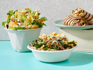 A salad, warm bowl, dressing, and apple slices